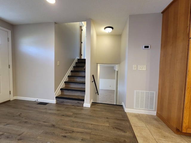 entryway with visible vents, baseboards, and wood finished floors