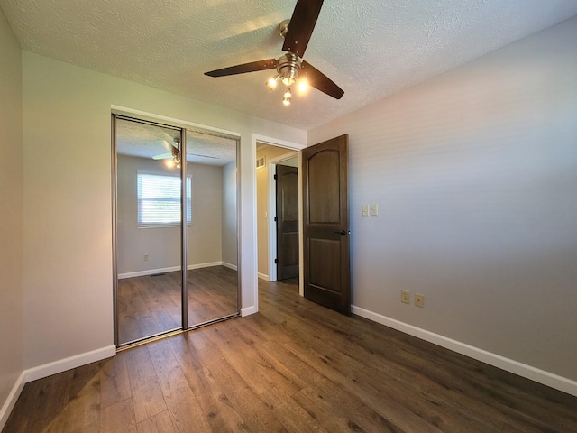 unfurnished bedroom featuring baseboards, ceiling fan, a closet, wood-type flooring, and a textured ceiling