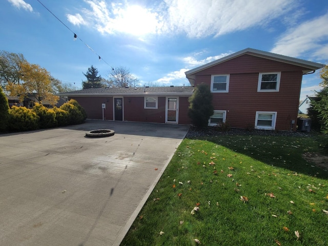 view of front facade with a patio, an outdoor fire pit, and a front lawn