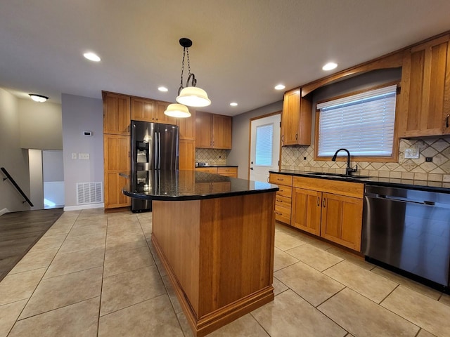 kitchen featuring visible vents, dishwasher, light tile patterned floors, refrigerator with ice dispenser, and a sink