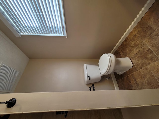 bathroom with toilet and baseboards