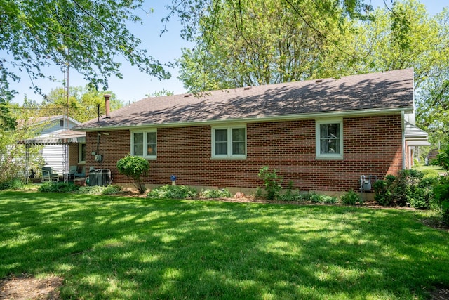 106 Westview Dr, Arcanum, OH 45304 - back of house with a lawn, brick siding, and a shingled roof