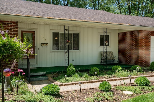 106 Westview Dr, Arcanum, OH 45304 - view of exterior entry featuring brick siding, a shingled roof, and a porch