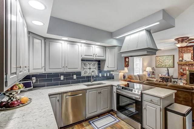 kitchen featuring appliances with stainless steel finishes, gray cabinets, and a sink