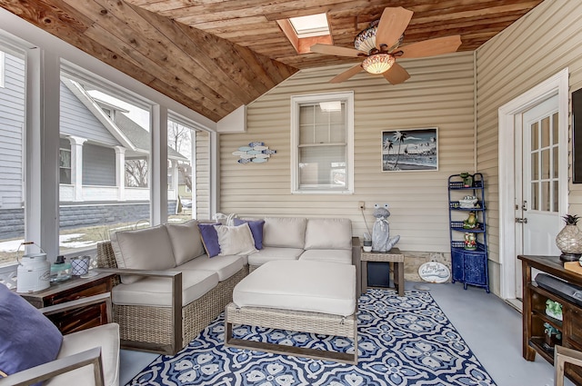 sunroom / solarium with lofted ceiling with skylight, wooden ceiling, and a ceiling fan