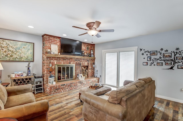 living room featuring ceiling fan, recessed lighting, wood finished floors, baseboards, and a brick fireplace