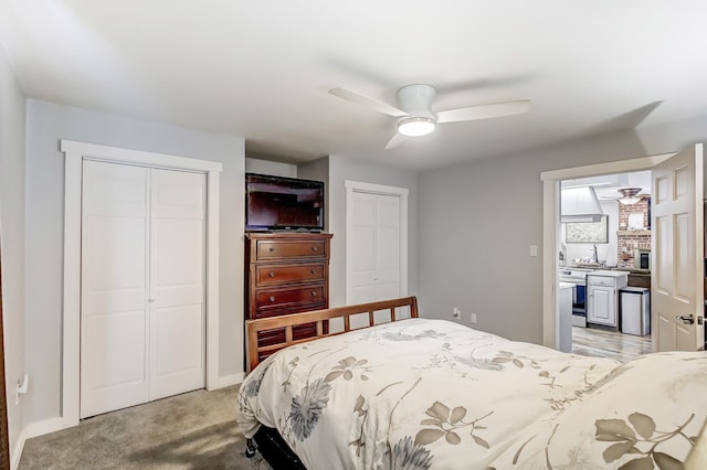 bedroom with light carpet, a ceiling fan, and multiple closets