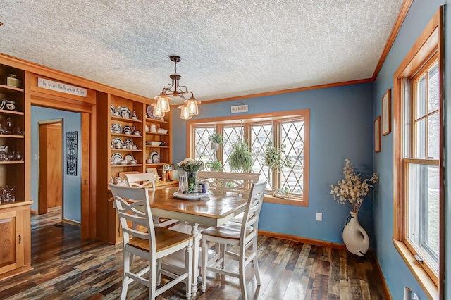 dining room featuring dark wood-style floors, ornamental molding, a textured ceiling, and an inviting chandelier