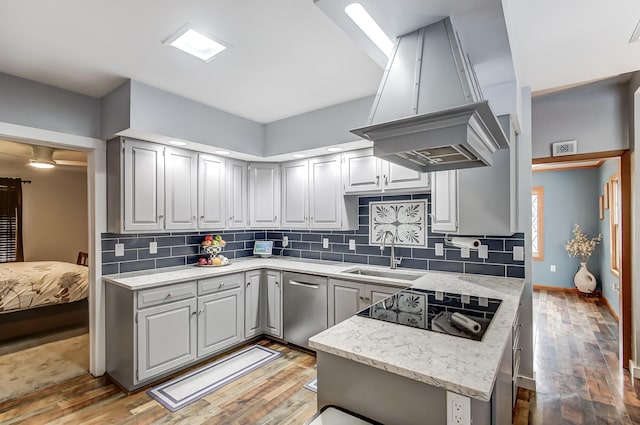 kitchen featuring light wood-style flooring, island exhaust hood, black electric stovetop, and a sink