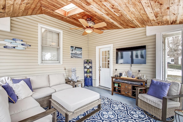 living area featuring lofted ceiling with skylight, wood ceiling, and concrete flooring