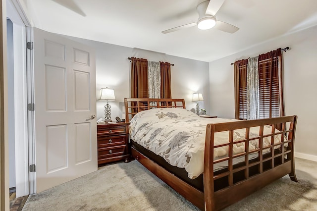 bedroom with light carpet, a ceiling fan, and baseboards