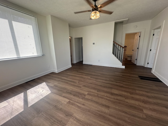 301 Plumvalley St, Bellefontaine, OH 43311 - unfurnished room with a textured ceiling, stairway, a ceiling fan, wood finished floors, and baseboards