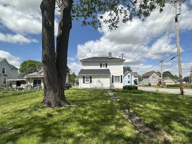 301 Plumvalley St, Bellefontaine, OH 43311 - back of house with a chimney, a lawn, a residential view, and a shingled roof