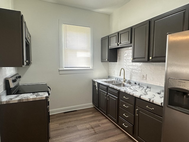 301 Plumvalley St, Bellefontaine, OH 43311 - kitchen with appliances with stainless steel finishes, a sink, tasteful backsplash, light countertops, and dark wood finished floors