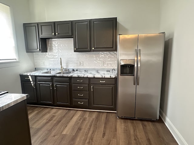 301 Plumvalley St, Bellefontaine, OH 43311 - kitchen featuring stainless steel refrigerator with ice dispenser, a sink, light countertops, dark wood-type flooring, and decorative backsplash