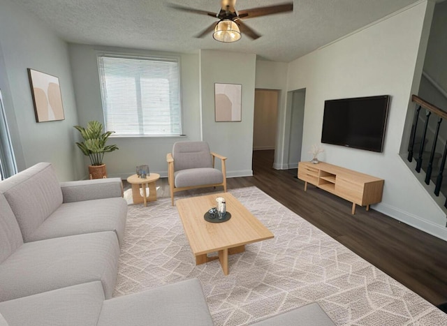 301 Plumvalley St, Bellefontaine, OH 43311 - living room featuring wood finished floors, ceiling fan, baseboards, a textured ceiling, and stairway