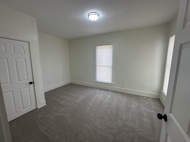 301 Plumvalley St, Bellefontaine, OH 43311 - spare room with dark carpet, baseboards, and a textured ceiling