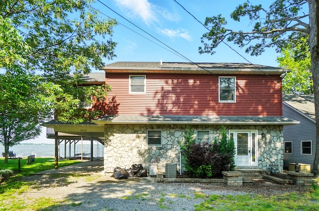 9113 Lake Ave, Huntsville, OH 43324 - back of property featuring stone siding, driveway, a water view, and a carport