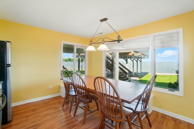 9113 Lake Ave, Huntsville, OH 43324 - dining space with light wood-type flooring, a water view, and stairway