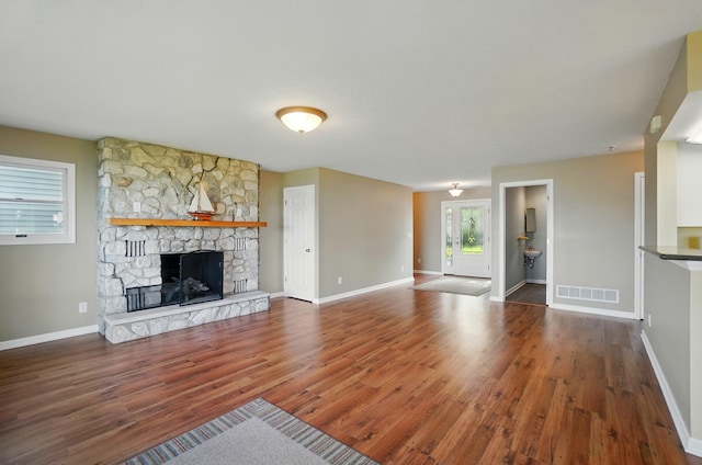 9113 Lake Ave, Huntsville, OH 43324 - unfurnished living room with wood finished floors and a stone fireplace