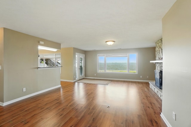 9113 Lake Ave, Huntsville, OH 43324 - unfurnished living room featuring wood finished floors and a fireplace