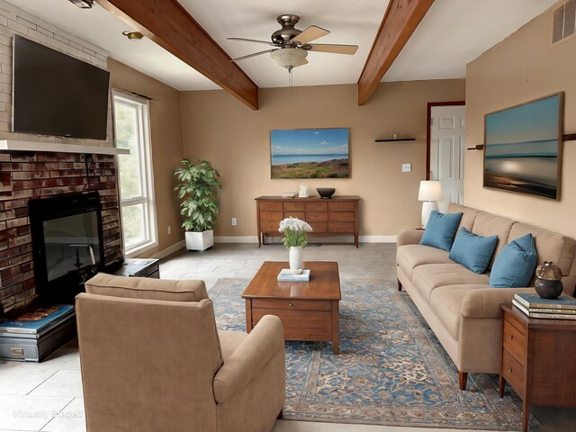 living room with beamed ceiling, light tile patterned flooring, a brick fireplace, and ceiling fan