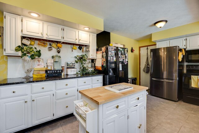 kitchen featuring decorative backsplash, black appliances, dark stone counters, and white cabinets