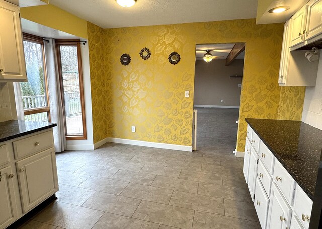 kitchen featuring dark stone countertops and white cabinets