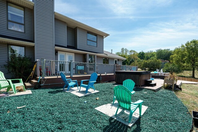 exterior space featuring a hot tub, a deck, and a patio