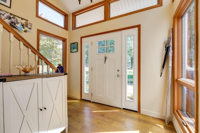 foyer entrance featuring lofted ceiling and light hardwood / wood-style floors