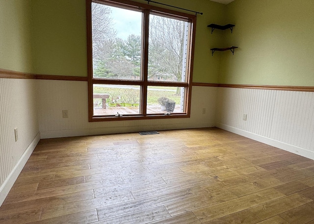 empty room with light hardwood / wood-style flooring and a healthy amount of sunlight