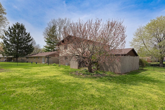 view of home's exterior with a lawn and fence