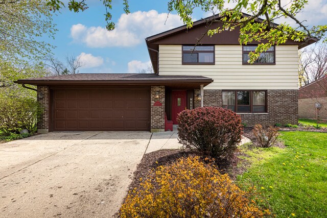 view of front of property featuring an attached garage, brick siding, driveway, and a front yard