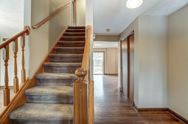 staircase with baseboards and hardwood / wood-style flooring