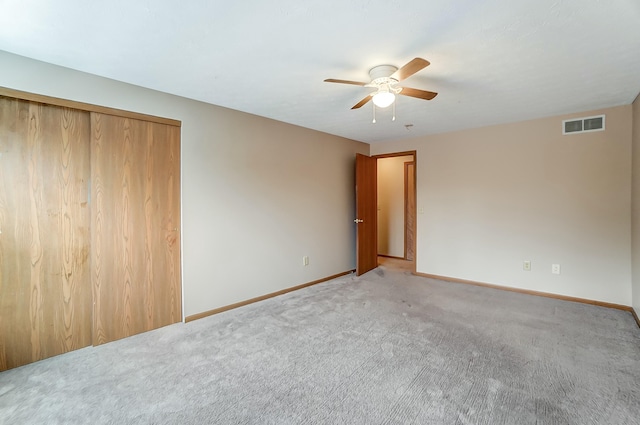 unfurnished bedroom with carpet floors, visible vents, ceiling fan, and baseboards