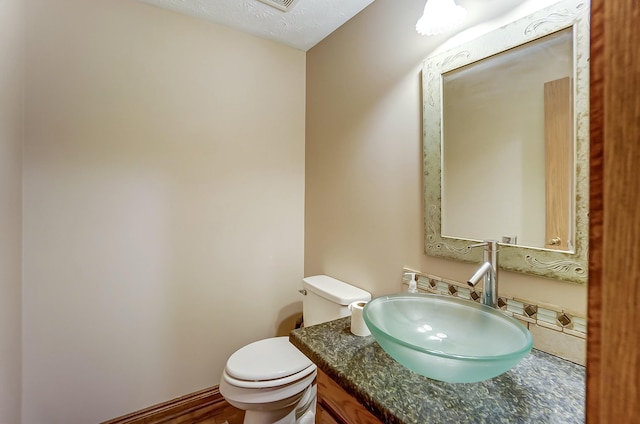 half bathroom with vanity and toilet