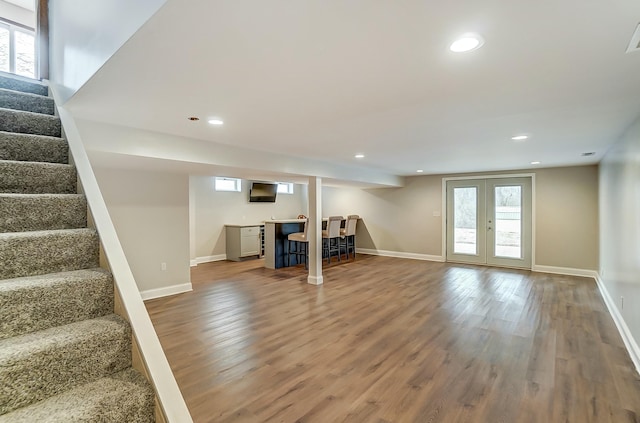 below grade area with plenty of natural light, stairs, wood finished floors, and recessed lighting