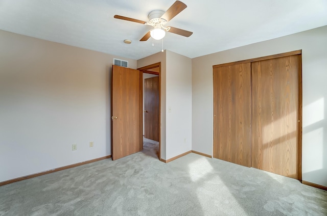 unfurnished bedroom with visible vents, baseboards, a ceiling fan, light colored carpet, and a closet