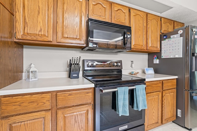 1686 Laurel Creek Dr, Troy, OH 45373 - kitchen featuring appliances with stainless steel finishes, light countertops, and brown cabinetry