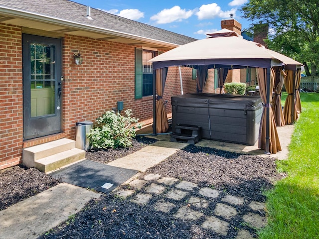 1686 Laurel Creek Dr, Troy, OH 45373 - back of house with a hot tub, brick siding, entry steps, a gazebo, and a chimney