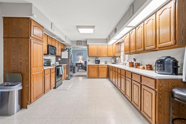 1686 Laurel Creek Dr, Troy, OH 45373 - kitchen featuring black appliances, light countertops, light floors, and brown cabinetry