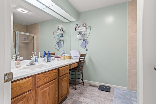 1686 Laurel Creek Dr, Troy, OH 45373 - bathroom with a stall shower, vanity, and wood finished floors