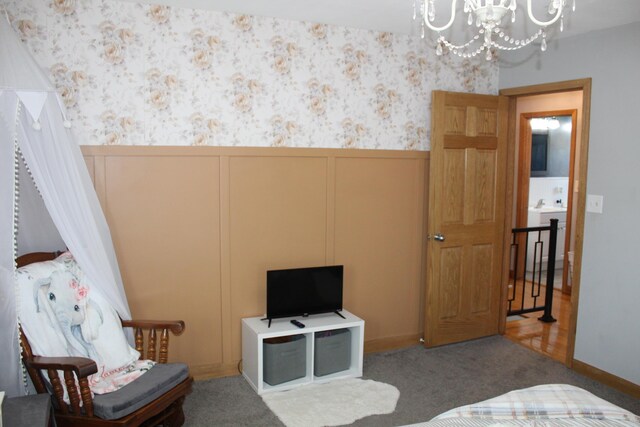 interior space with a decorative wall, wainscoting, wallpapered walls, and an inviting chandelier
