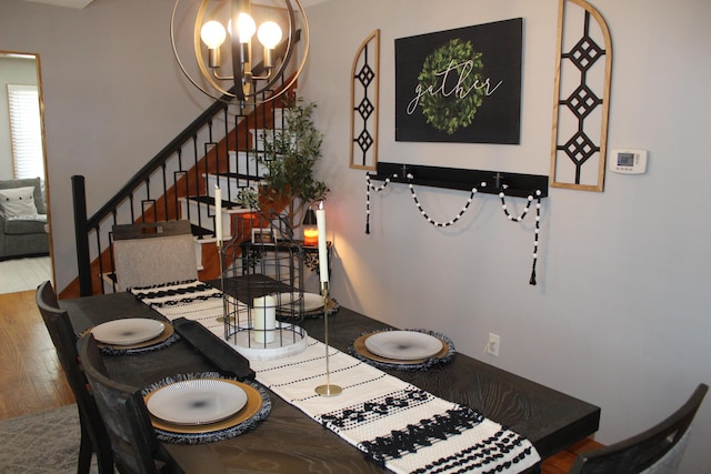 dining room with a chandelier, stairway, and wood finished floors