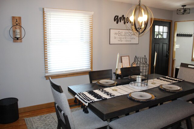 dining room with baseboards, an inviting chandelier, and wood finished floors