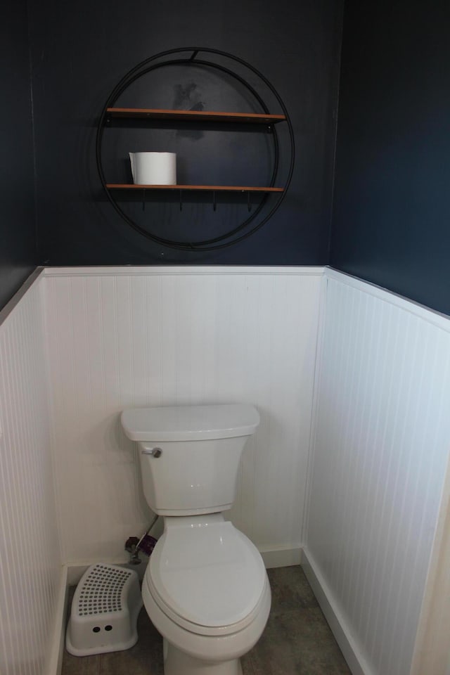 bathroom featuring toilet and wainscoting