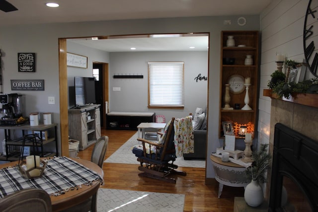 living room featuring a tiled fireplace, recessed lighting, and wood finished floors
