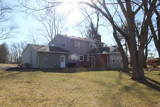 back of house with a yard, cooling unit, and a chimney