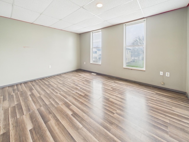 spare room featuring a drop ceiling and wood finished floors