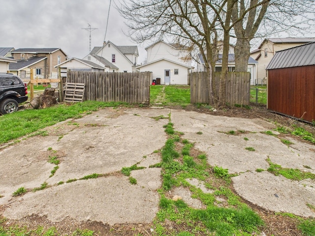 view of yard with a residential view, an outdoor structure, and fence